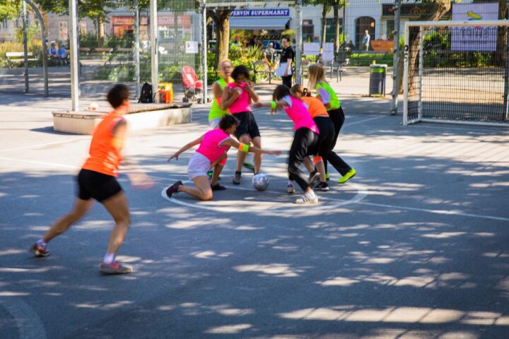 Mädchen und junge Frauen beim Fußballspielen im Käfig