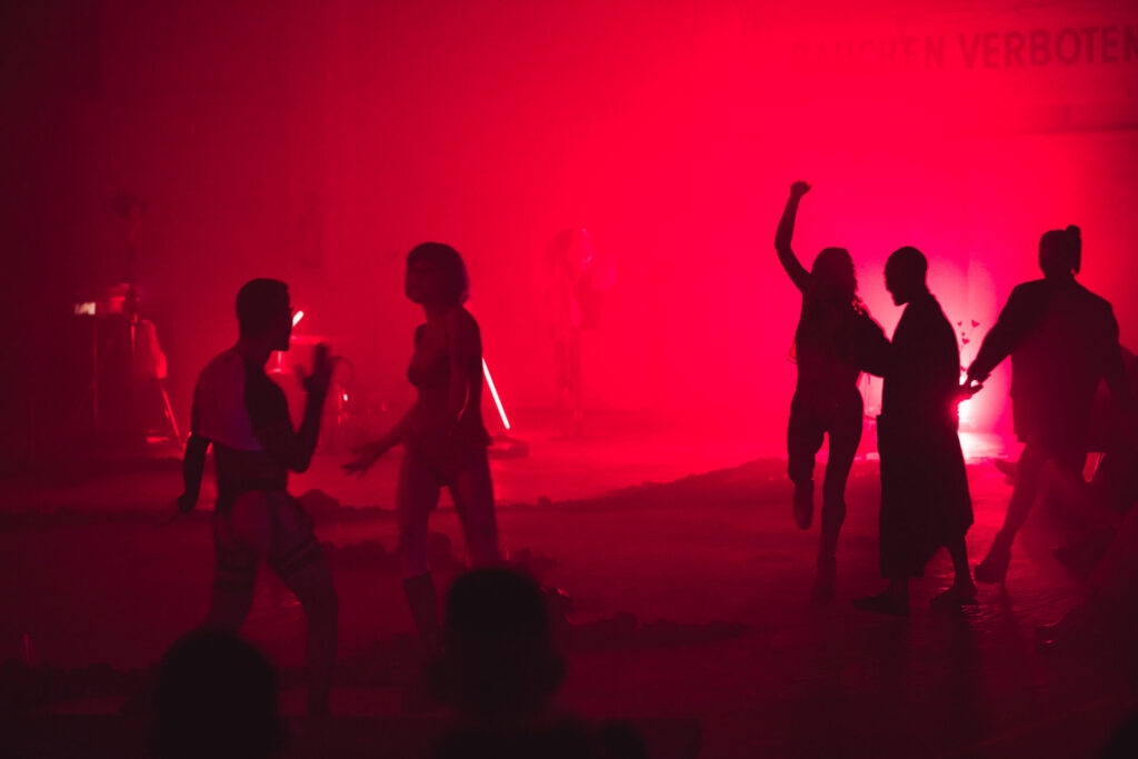 Umrisse von tanzenden Leuten in rotem Licht