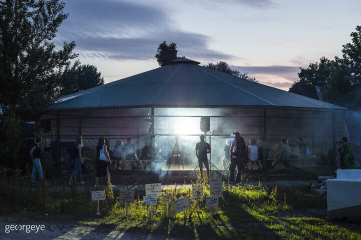 Pavillion bei Sonnenuntergang mit Publkum, Licht und Nebel