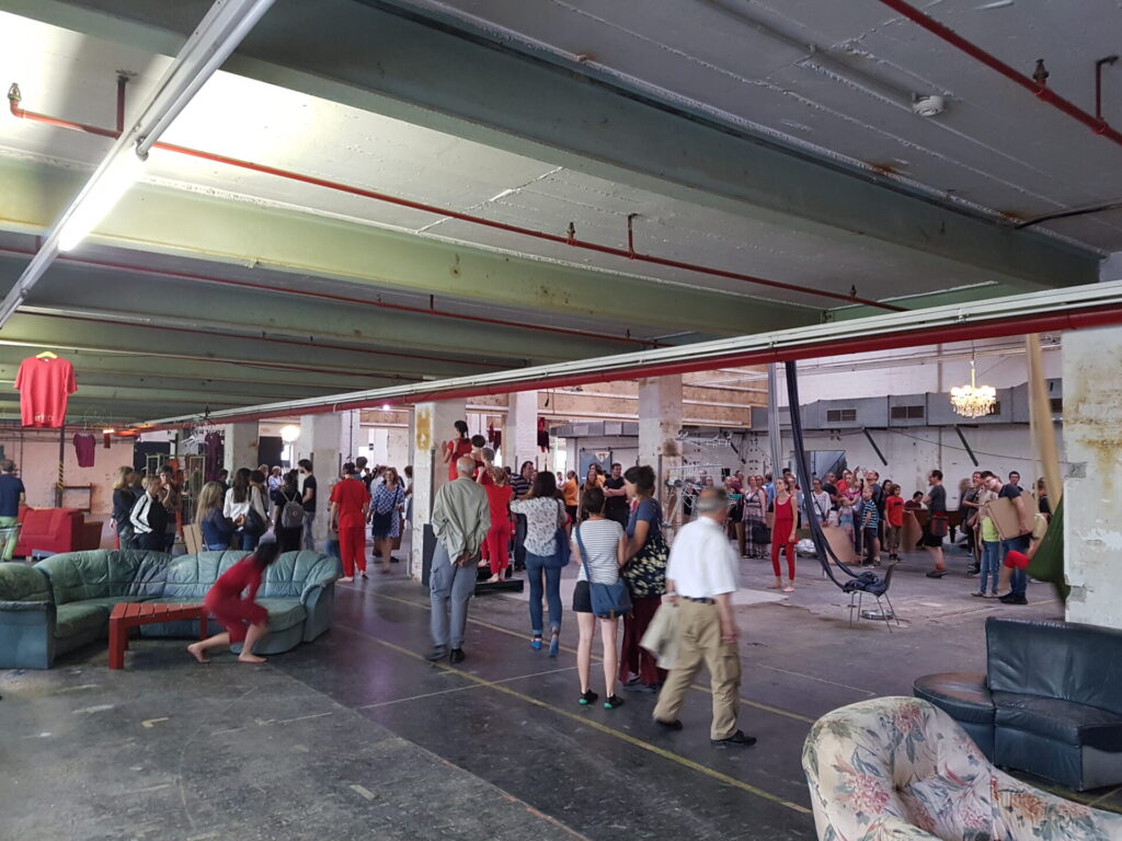 © Erich Sperger Publikum in Fabrikhalle