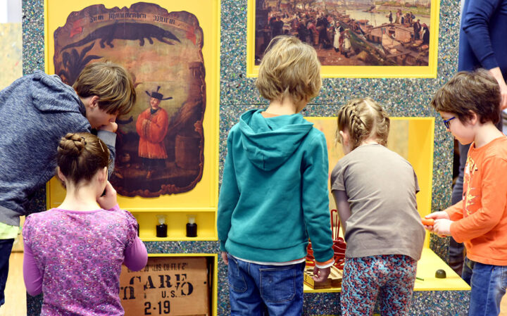 Wand mit Bildern vor der Kinder stehen