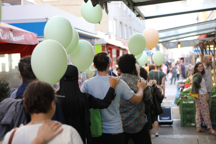 Leute mit Luftballons am Brunnenmarkt